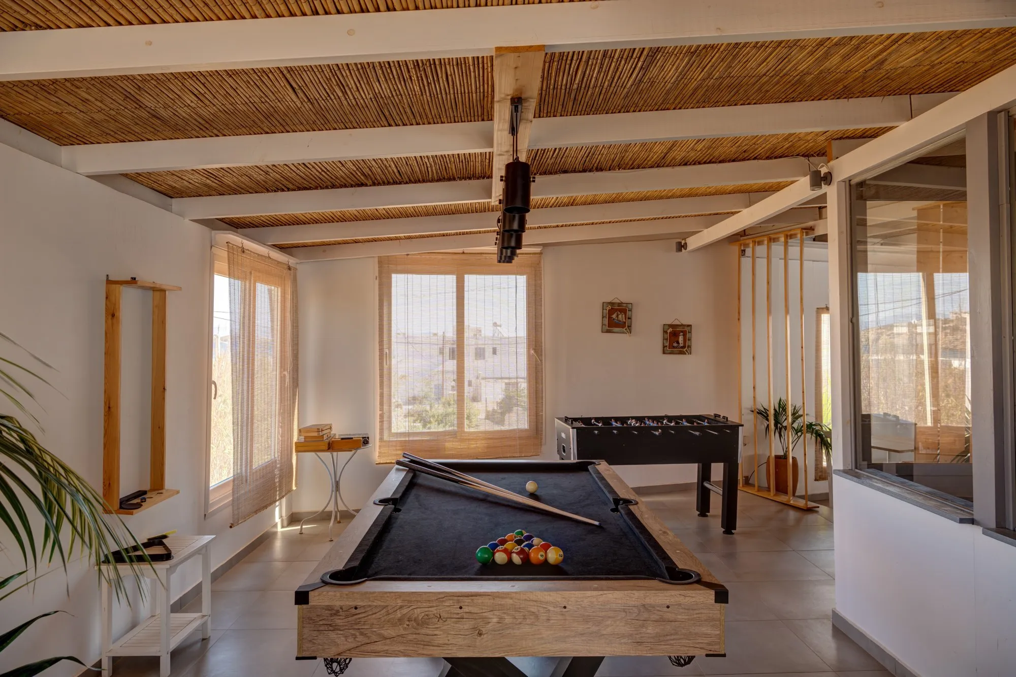 The entertainment area, with a billiards table and table football under a reed roof